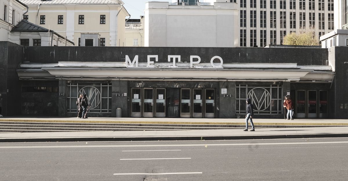 Entrance to a Moscow Metro station with pedestrians passing by on a sunny day.